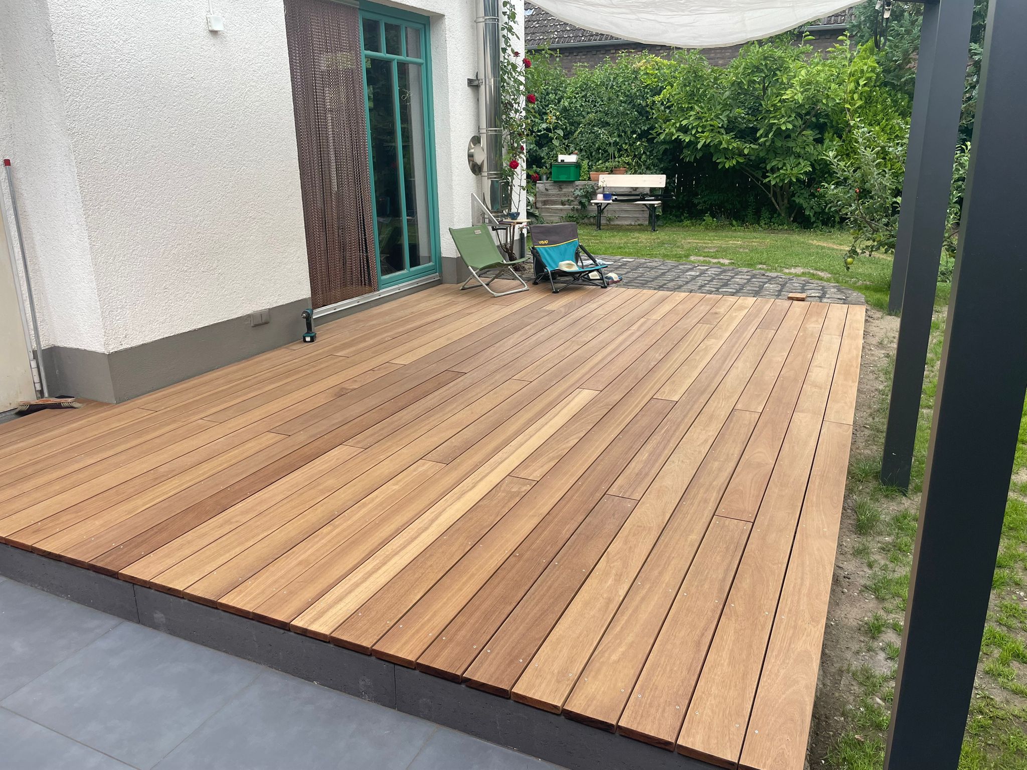 Große Holzterrasse aus warmem Naturholz im Gartenbereich